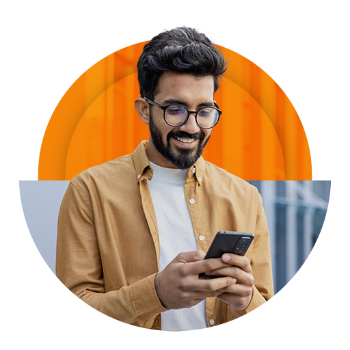 Homem jovem sorrindo e feliz, usando o celular