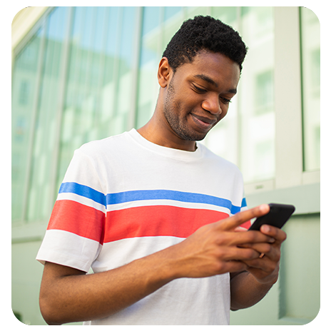 Uma mulher jovem negra sorrindo e feliz, digitando no notebook