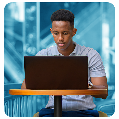 Homem usando notebook sentado à mesa.