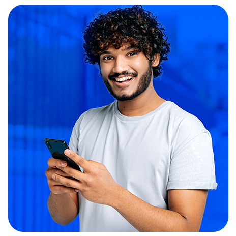 Homem sorrindo usando celular, com fundo azul.